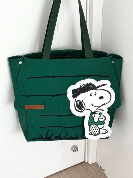 Green tote bag with a Peanuts Snoopy character design on a white background