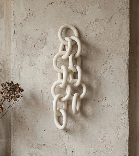 Decorative chain wall art on a textured beige wall