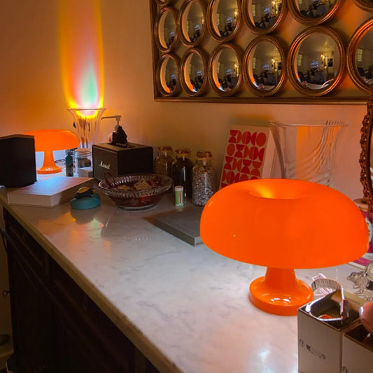 Orange lamp on a counter with decorative mirrors above