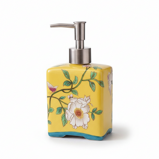 Yellow soap dispenser with floral design on a white background