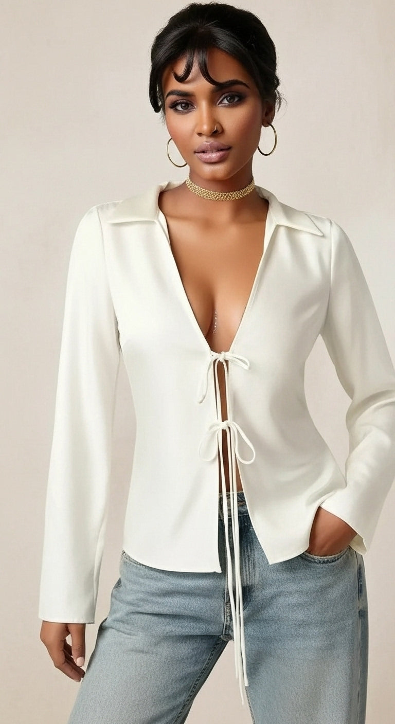 Woman wearing a white blouse with a deep neckline and light blue jeans on a beige background