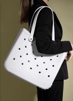 A person holding a white EVA tote bag with a dotted pattern.
