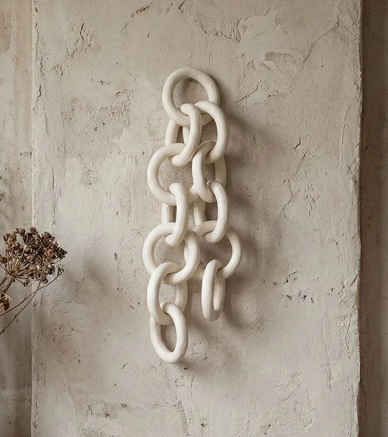 Decorative chain wall art on a textured beige wall