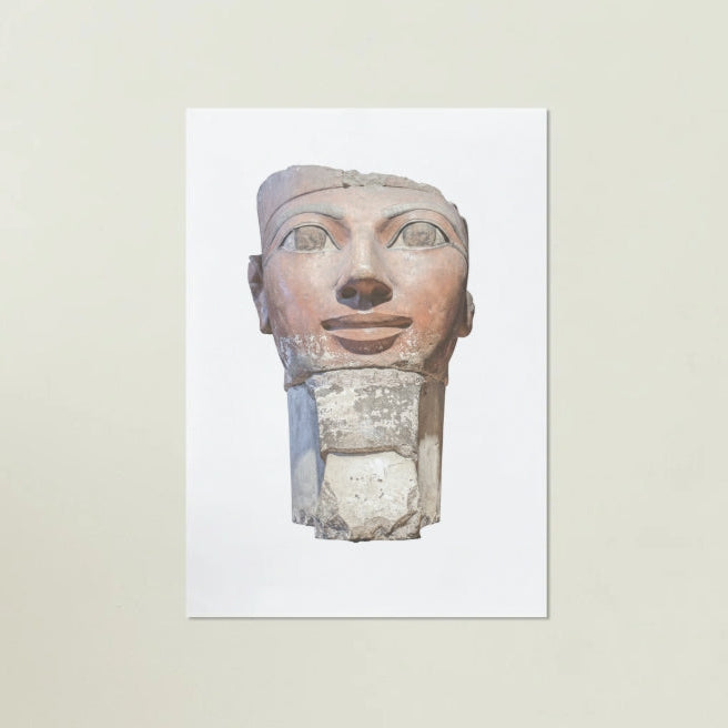 Egyptian stone sculpture of a face on a white background