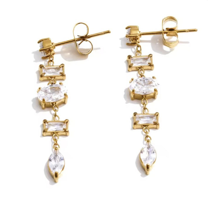 Gold earrings with clear gemstones on a white background