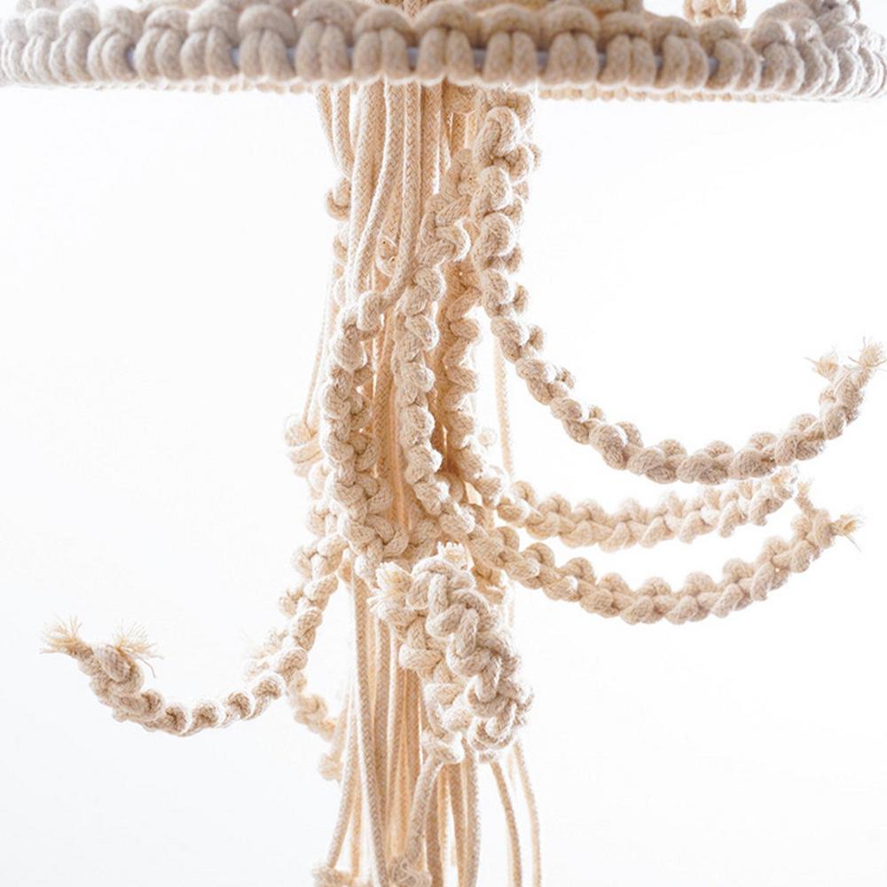 Close-up of a macrame plant hanger with intricate patterns on a white background