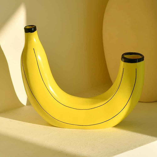 Yellow banana vase with black lines on a beige background