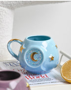 Blue ceramic mug with star and moon design on a newspaper