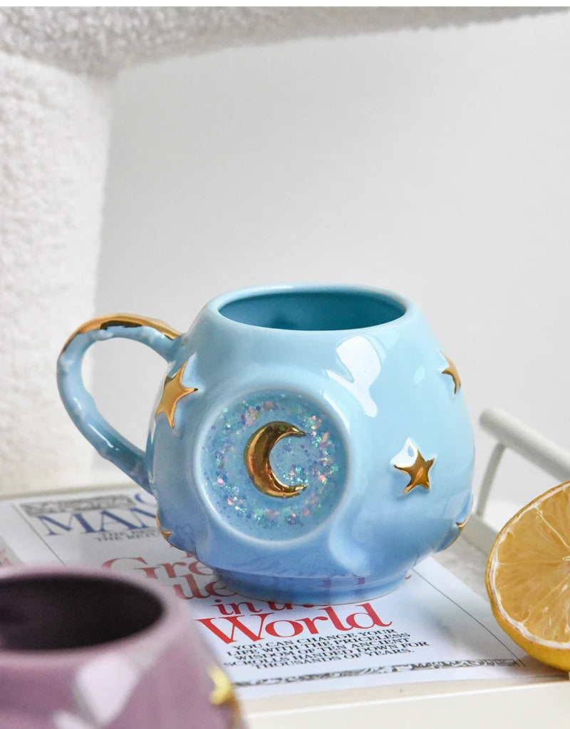 Blue ceramic mug with star and moon design on a newspaper
