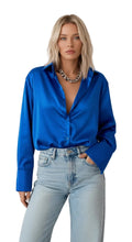 Woman wearing a blue shirt and light blue jeans on a white background