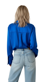 Person wearing a blue shirt and light blue jeans on a white background
