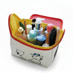 Snoopy makeup bag with cosmetic items including bottles and a brush on a white background
