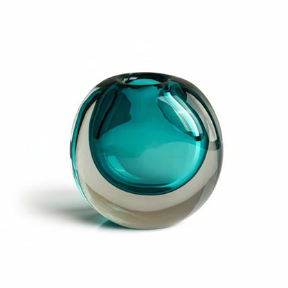 Teal and heavy glass sculpture on a white background