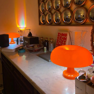 Orange lamp on a counter with decorative mirrors above