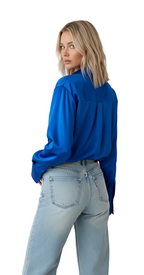 Person wearing a blue shirt and light blue jeans on a white background