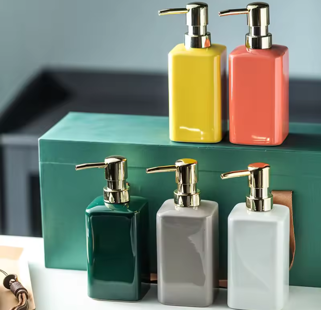 Set of colorful ceramic soap dispensers on a shelf with a neutral background